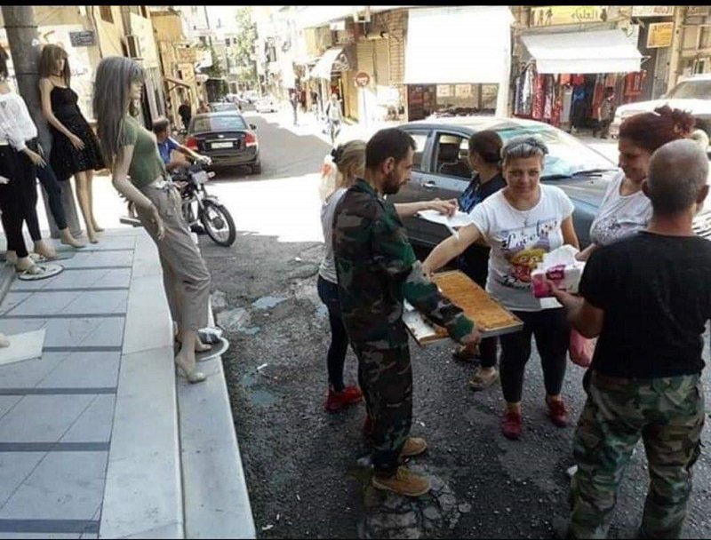 Syrians distributing sweets on the streets in Suqaylabiyah