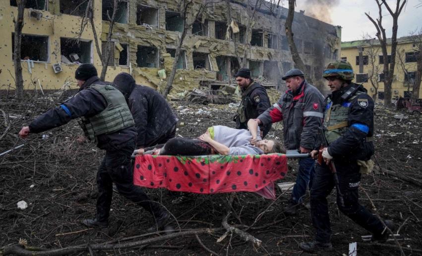 Allegedly wounded & pregnant woman carried thru dead tree branches in courtyard of Maternity & Pediatric Hospital occupied & emptied by Ukraine Nazis.