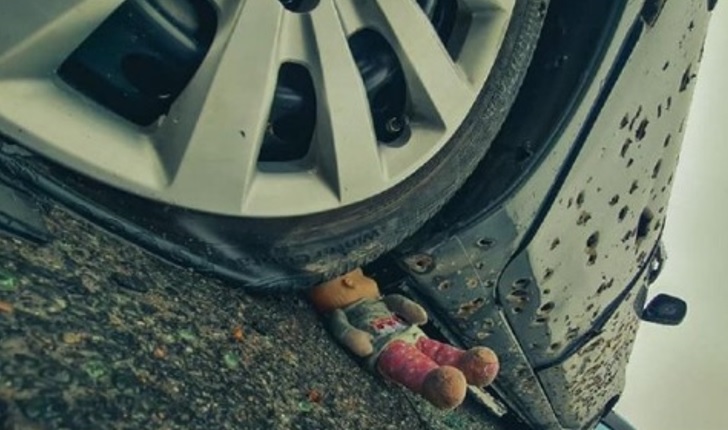 Do photographers carry dolls in their backpacks, to be used as setting props? Bucha, Ukraine.