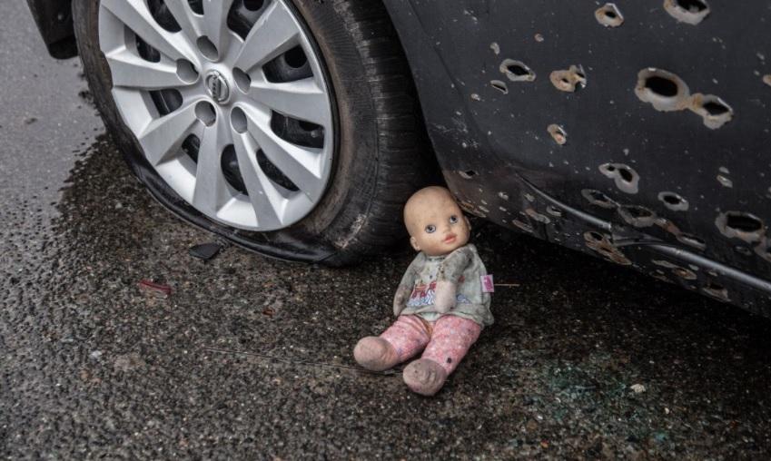 Do photographers carry dolls in their backpacks, to be used as setting props? Bucha, Ukraine.